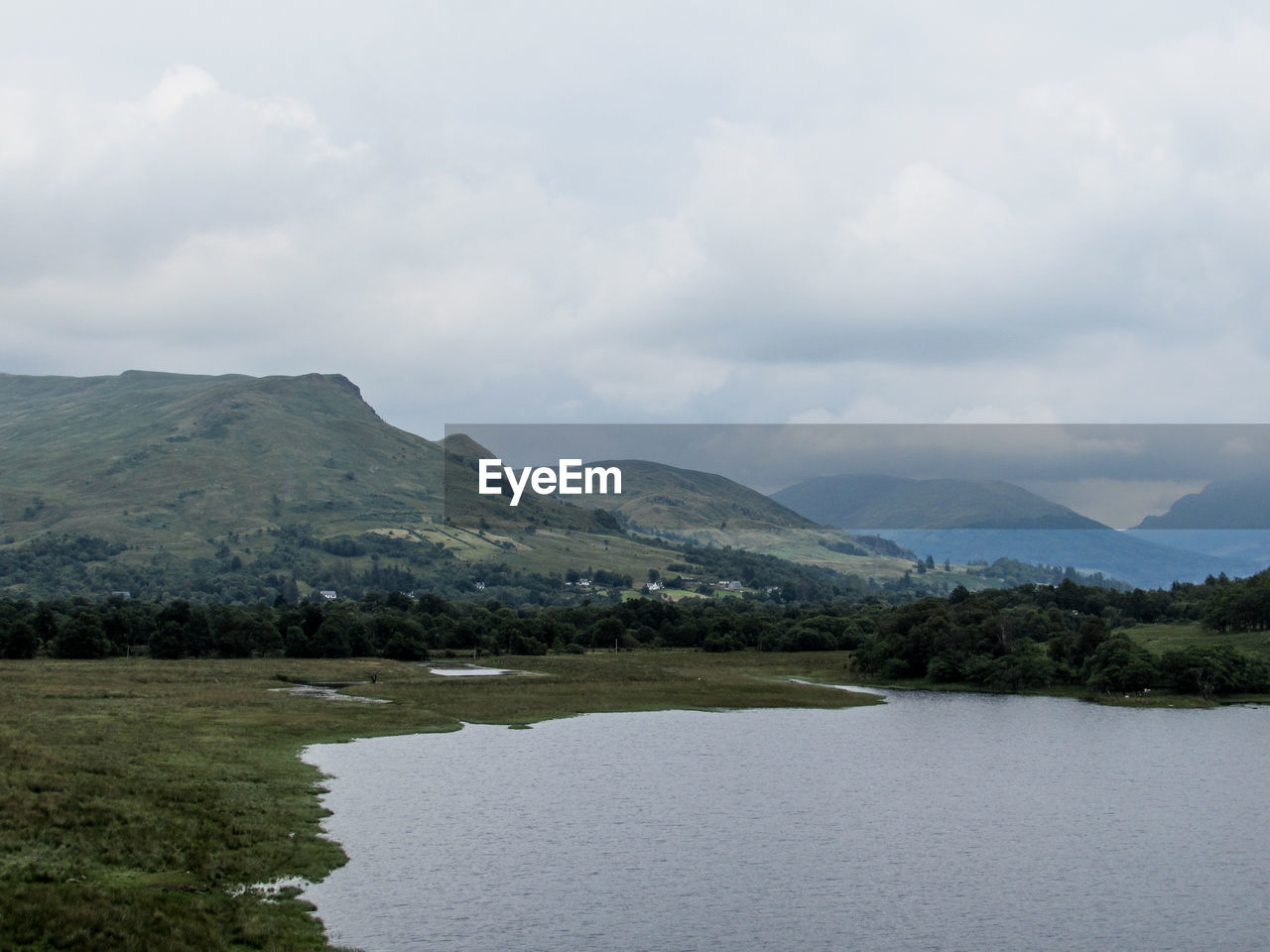 SCENIC VIEW OF RIVER AND MOUNTAINS AGAINST CLOUDY SKY