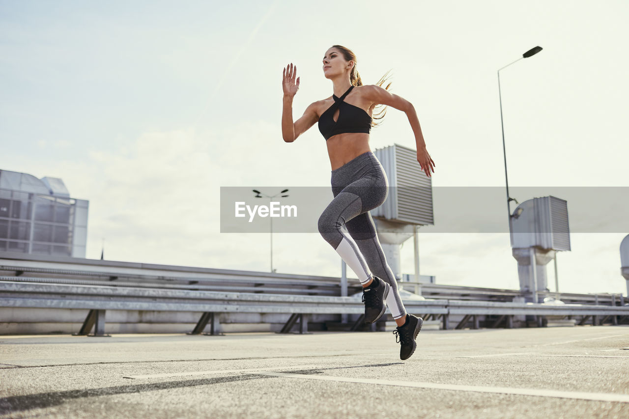 Young woman doing running exercises in the city
