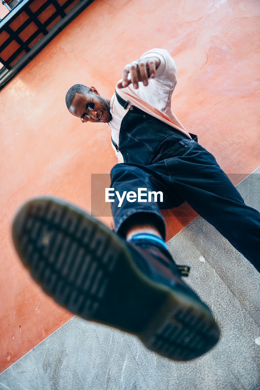 Low angle view of man standing against wall