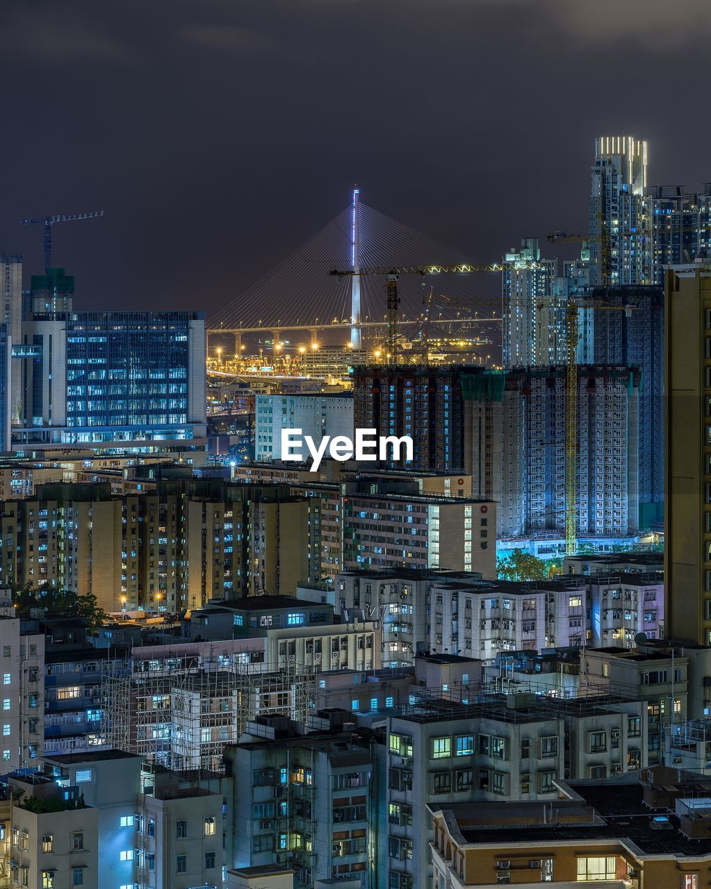 Illuminated cityscape against sky at night