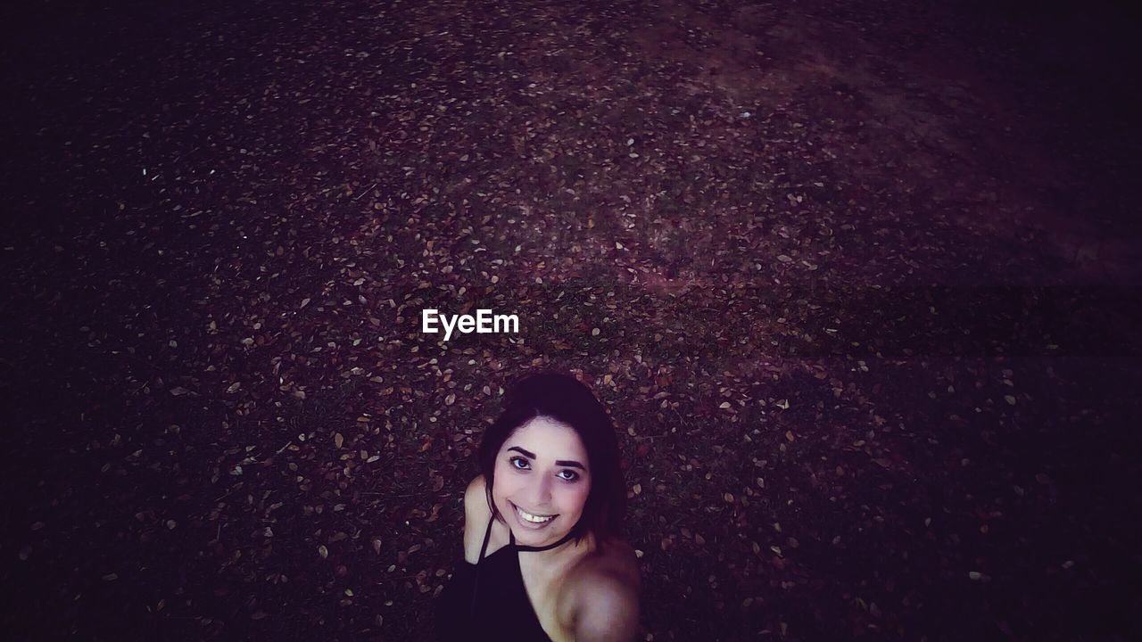 High angle view of smiling young woman standing on field