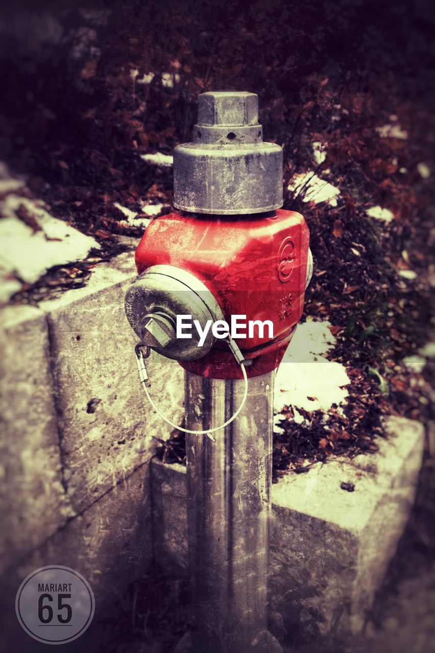 HIGH ANGLE VIEW OF FIRE HYDRANT AGAINST OLD WALL