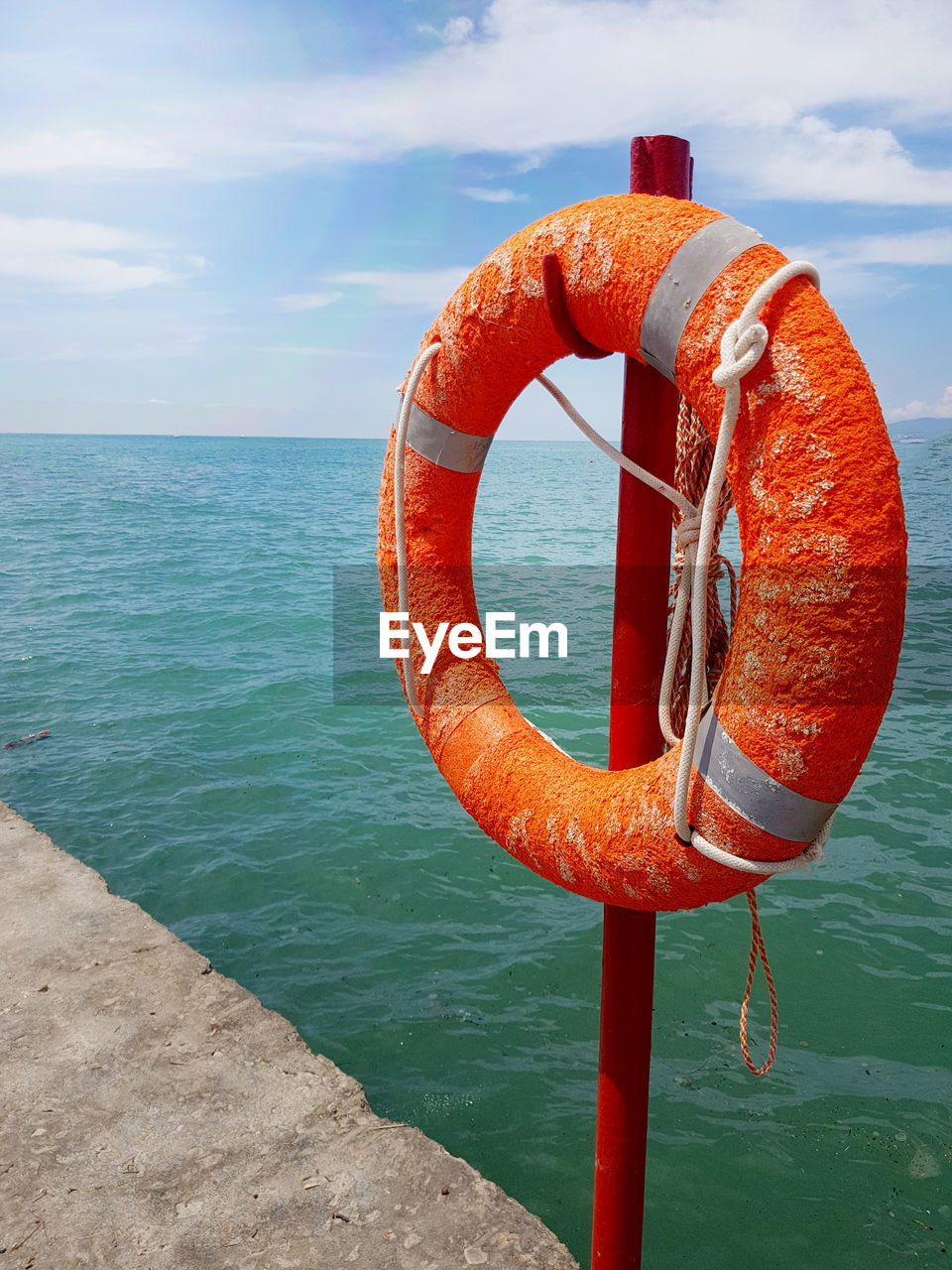lifebuoy, water, life belt, sea, protection, security, sky, nature, rope, buoy, day, orange color, tubing, no people, horizon over water, circle, tranquility, scenics - nature, horizon, geometric shape, beach, cloud, red, rescue, tube, outdoors, beauty in nature, land, vacation, shape, nautical vessel, tranquil scene, sunlight, hanging, transportation, metal
