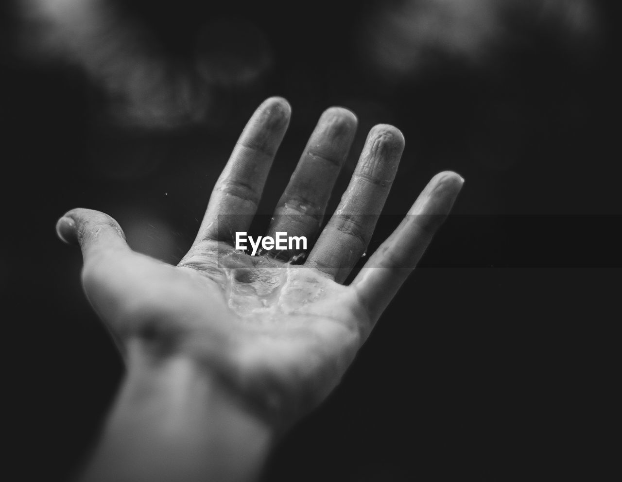Close-up of human hand against black background