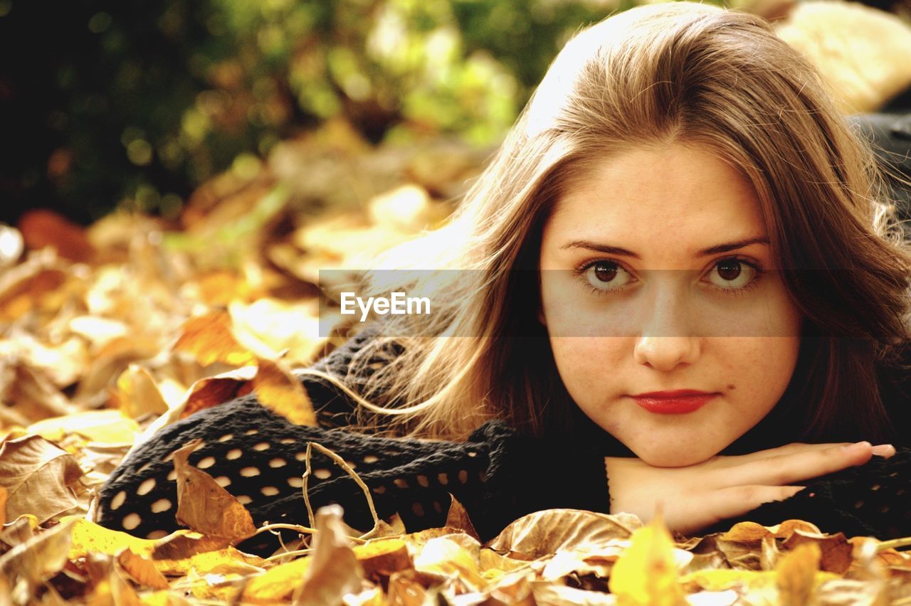 Teenage girl lying on autumn leaves