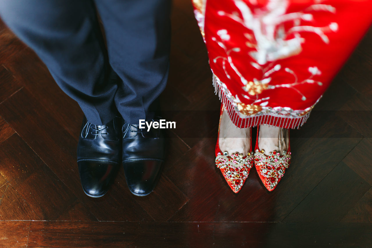 Low section of woman standing on hardwood floor