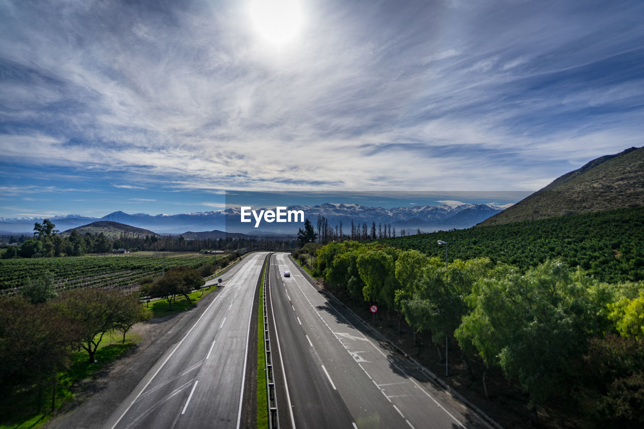 Road leading towards mountain against sky