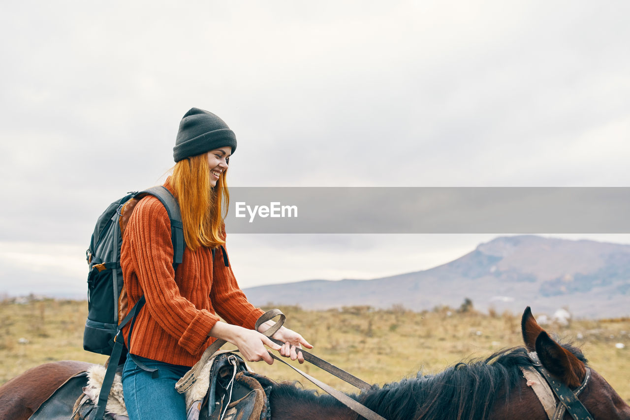 MAN RIDING HORSE CART ON MOUNTAIN