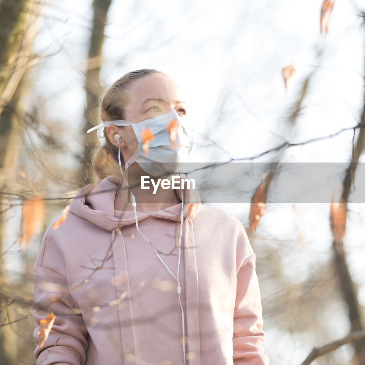 PORTRAIT OF YOUNG WOMAN STANDING AGAINST TREE