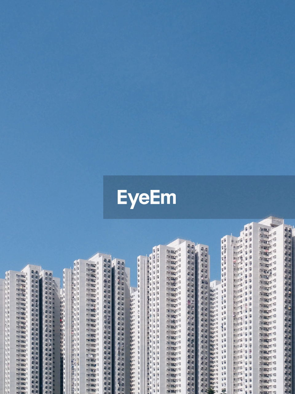 Low angle view of buildings against clear blue sky during sunny day