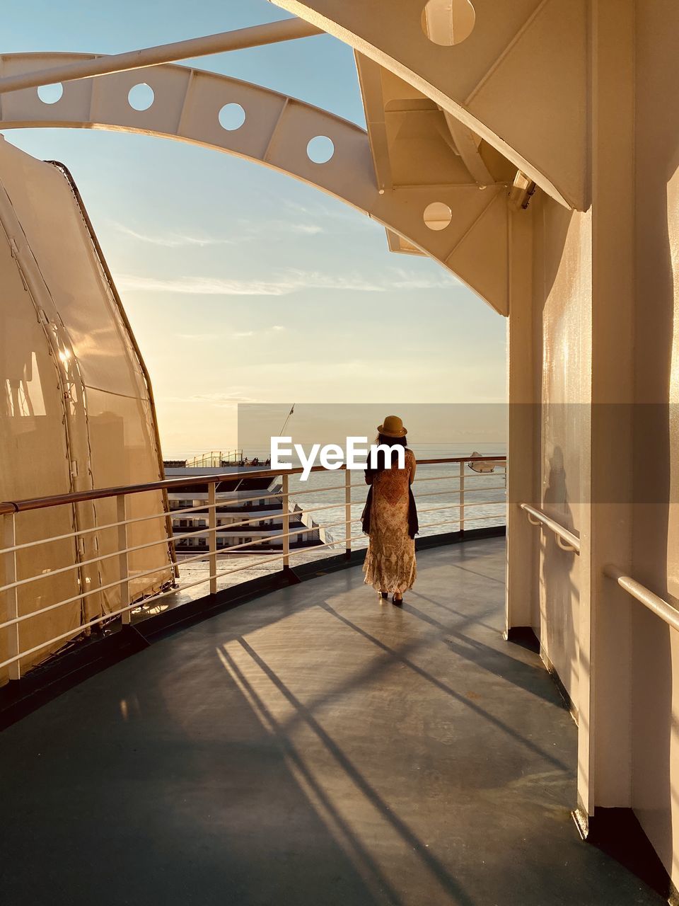 Rear view of woman walking on boat deck against sea