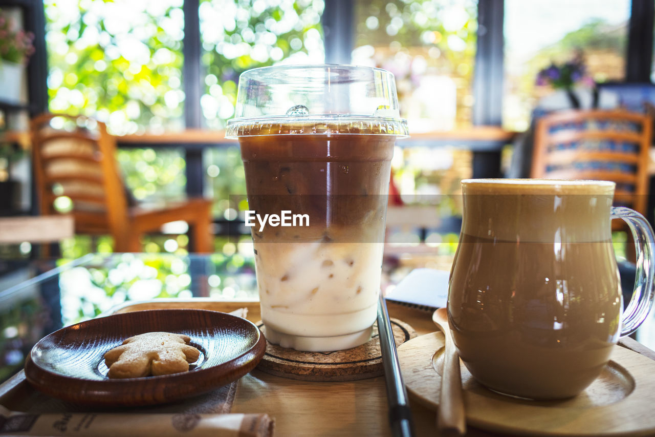 CLOSE-UP OF COFFEE WITH GLASS ON TABLE