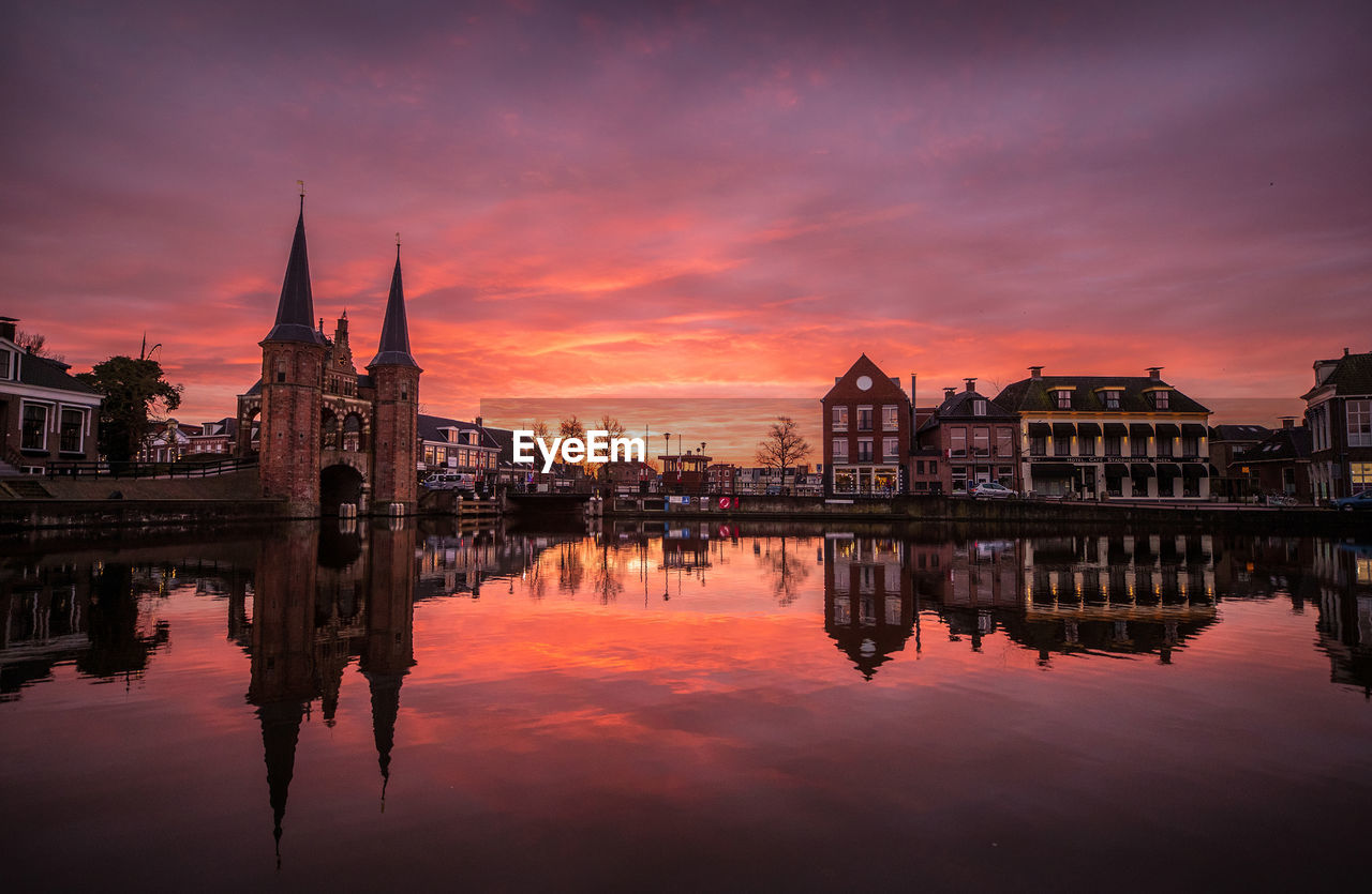 Reflection of buildings in river during sunset