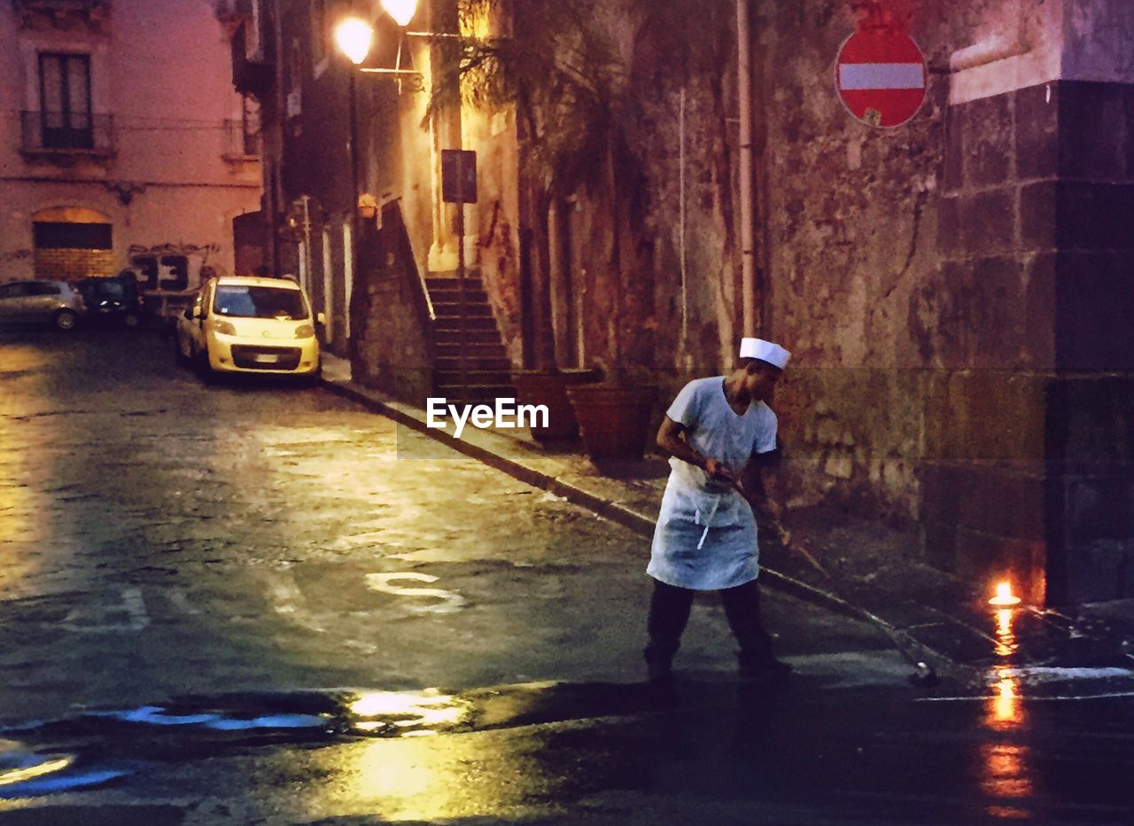 FULL LENGTH OF MAN WITH UMBRELLA ON STREET