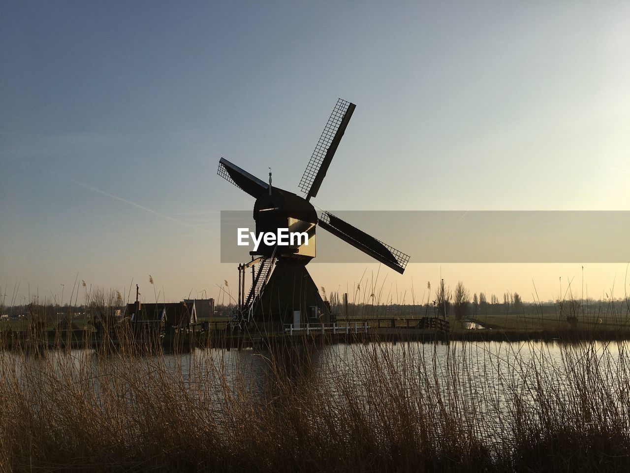 TRADITIONAL WINDMILL BY WINDMILLS AGAINST SKY