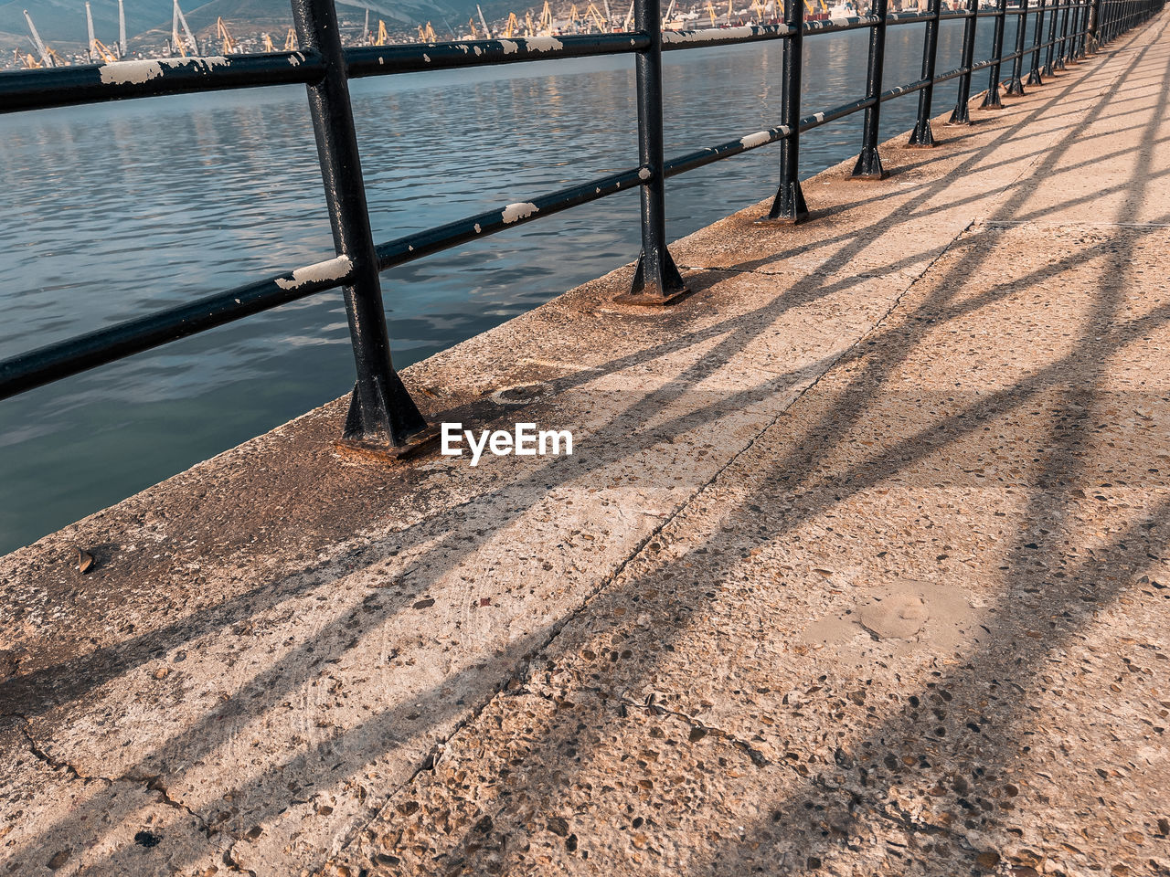 HIGH ANGLE VIEW OF WOODEN RAILING ON RIVER