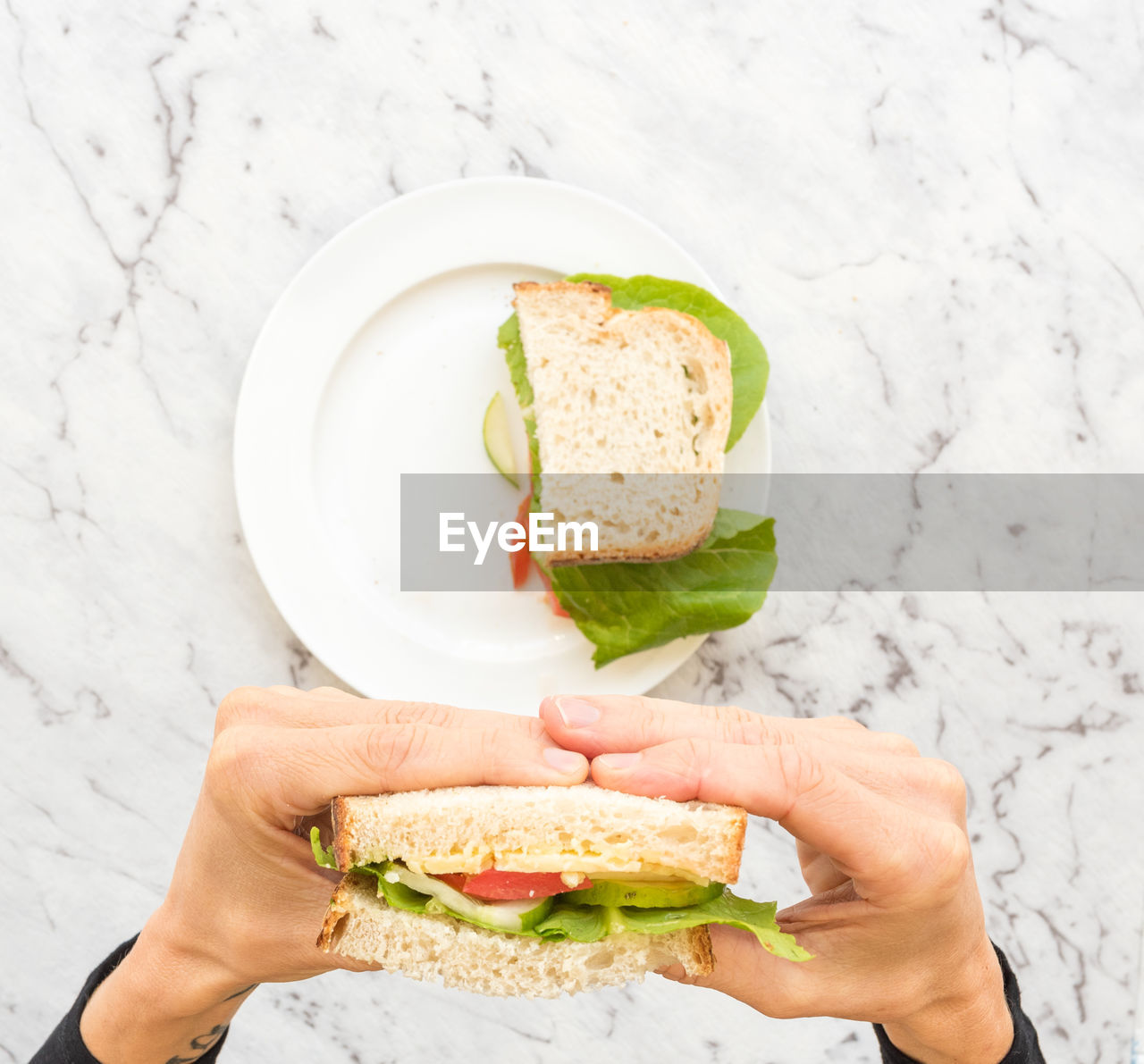 Cropped hands of woman holding sandwich