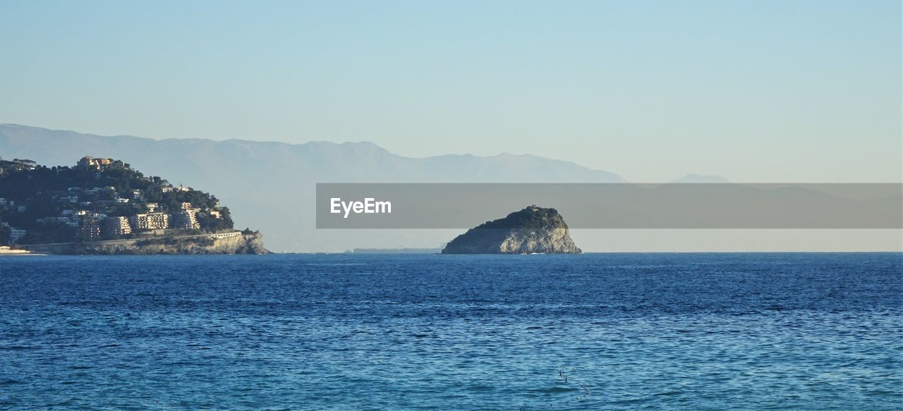 Scenic view of sea and island against clear sky