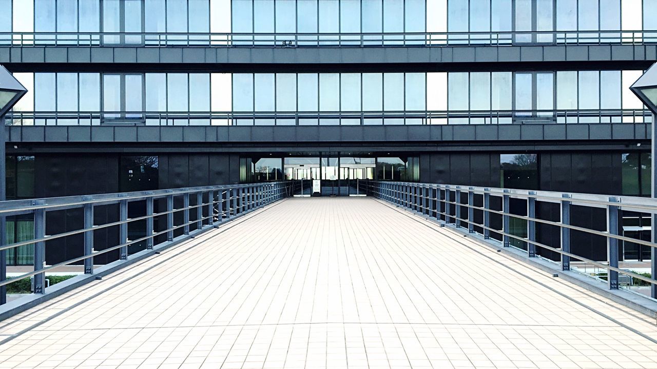 Footpath leading towards modern buildings on sunny day