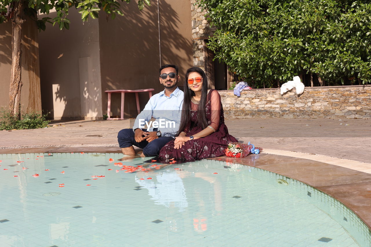 Portrait of smiling young couple sitting outdoors