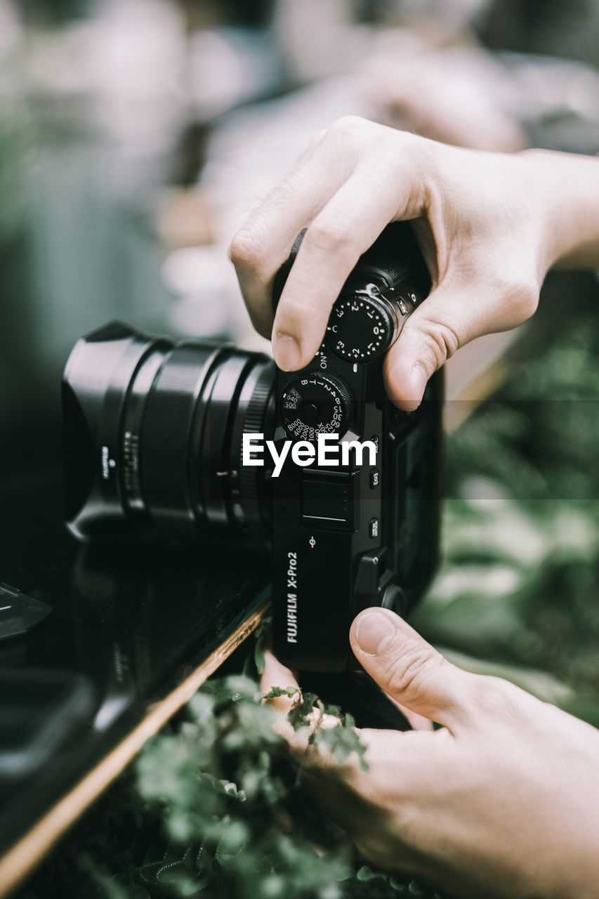 MIDSECTION OF MAN PHOTOGRAPHING CAMERA