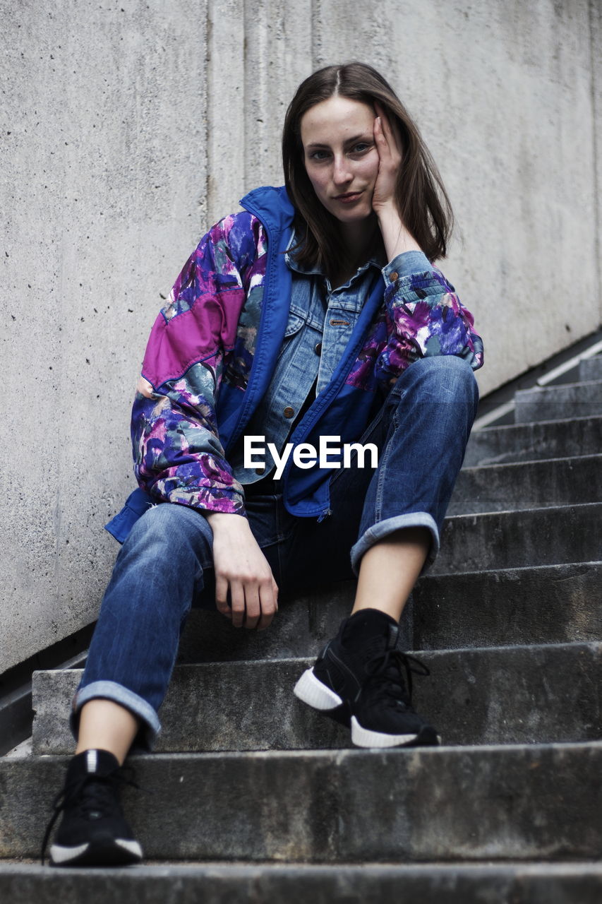 Portrait of young woman sitting on steps