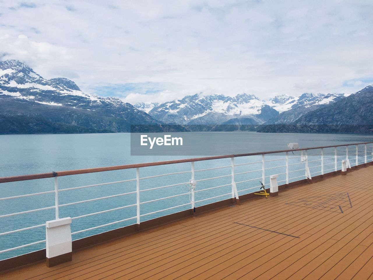 Scenic view of lake by snowcapped mountains against sky