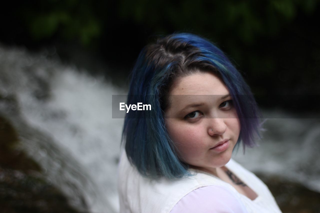 Close-up portrait of woman by waterfall