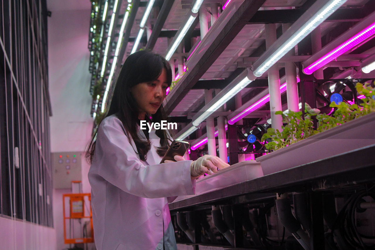 Dominique alexandra checking her indoor plants with the controlled environment agriculture system