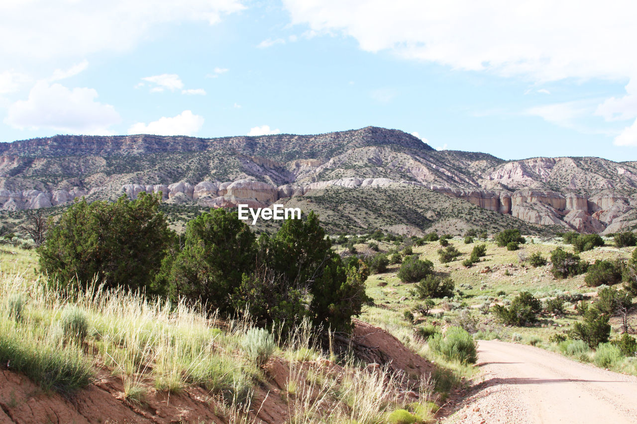 View of dirt road along rocky mountains