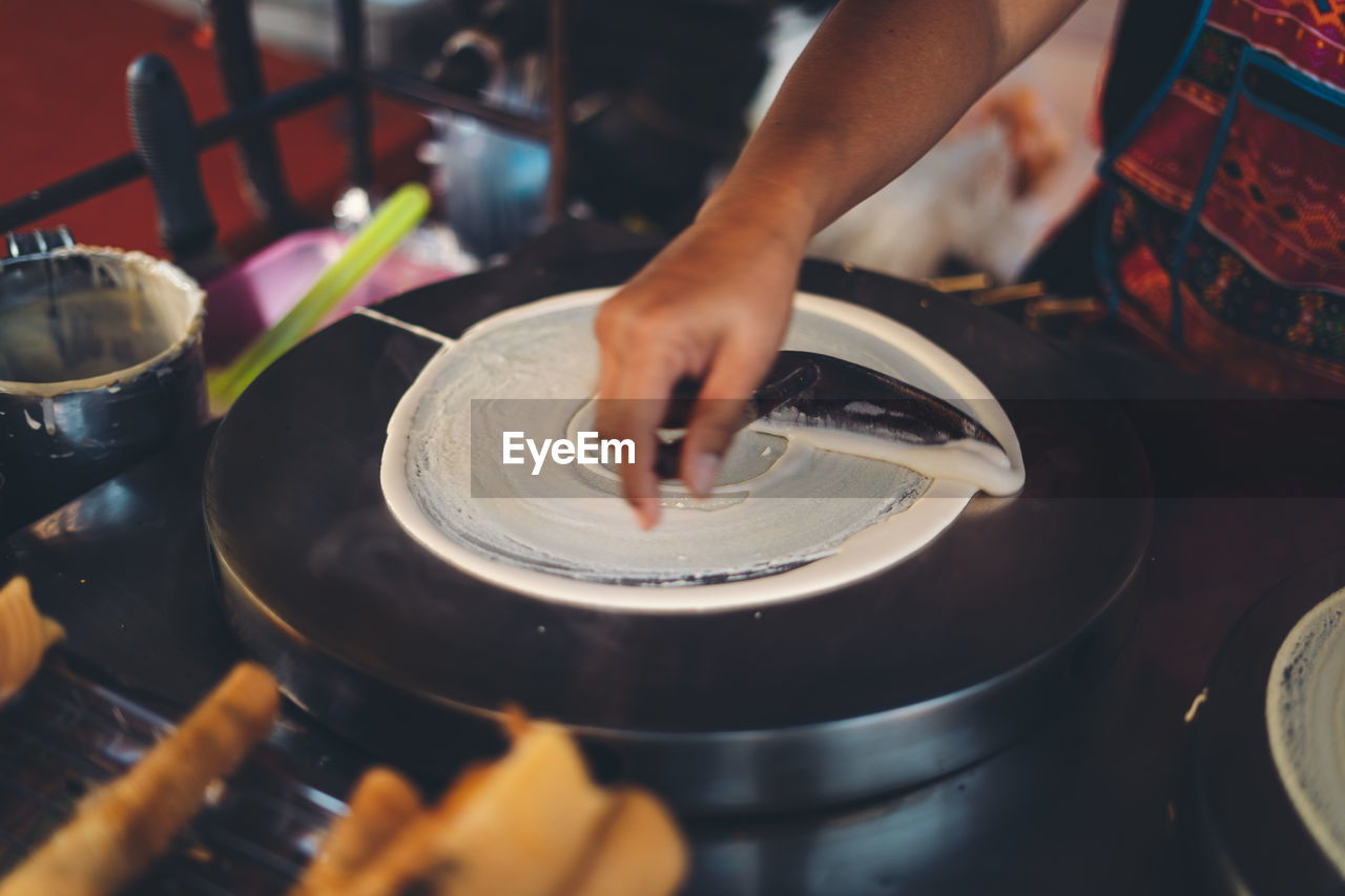 Midsection of person preparing food at market stall