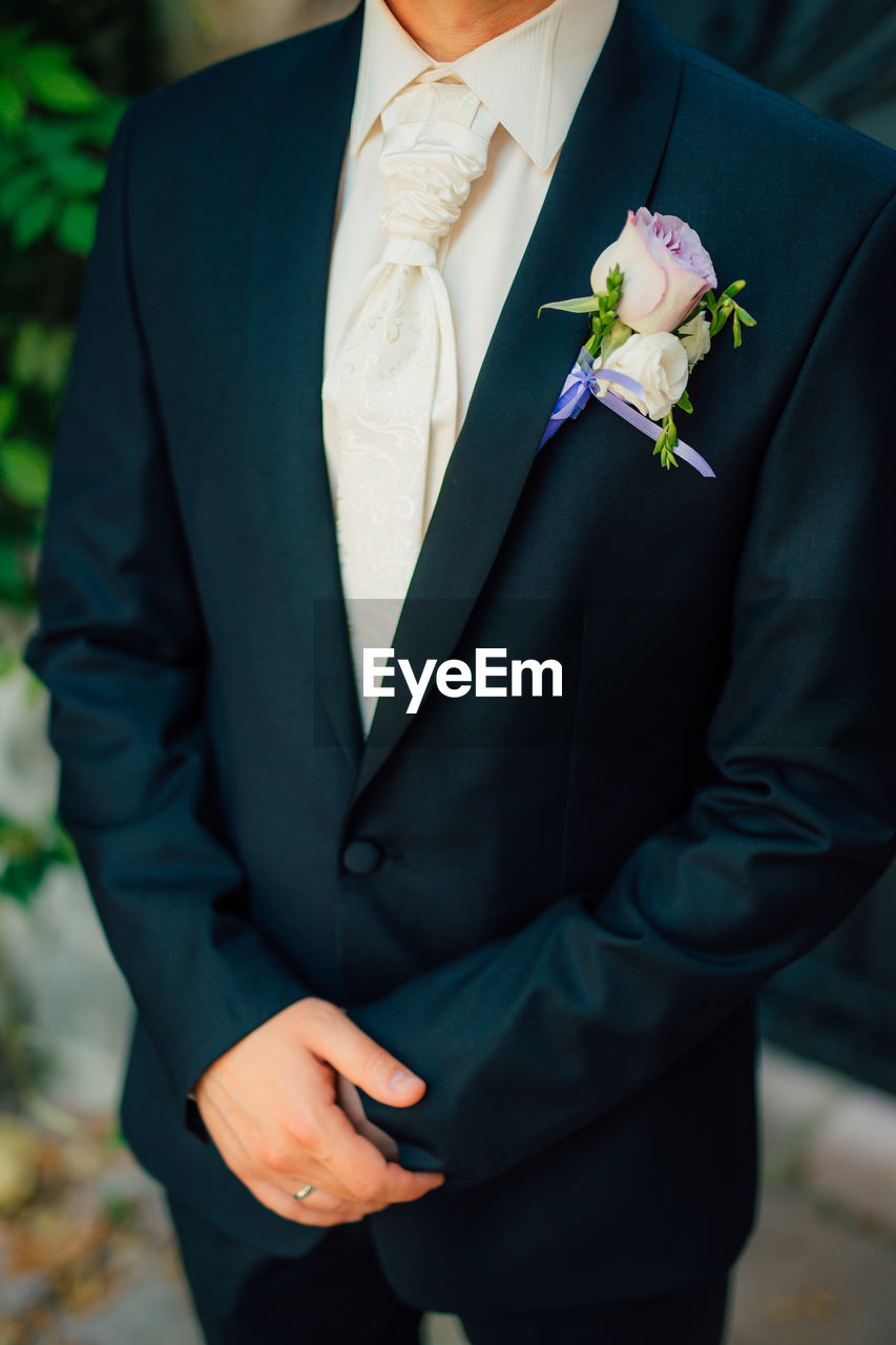 Midsection of man holding flower bouquet