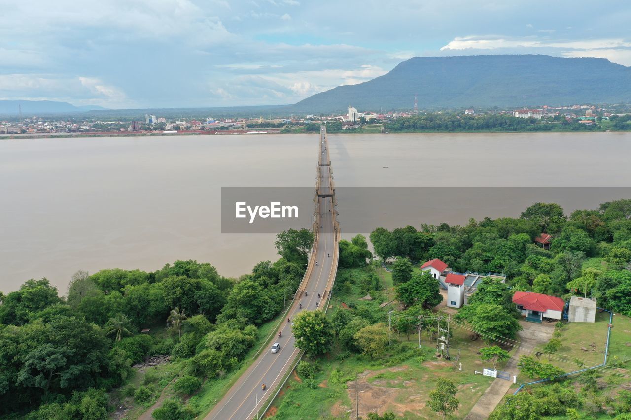 HIGH ANGLE VIEW OF CITY AND MOUNTAIN AGAINST SKY