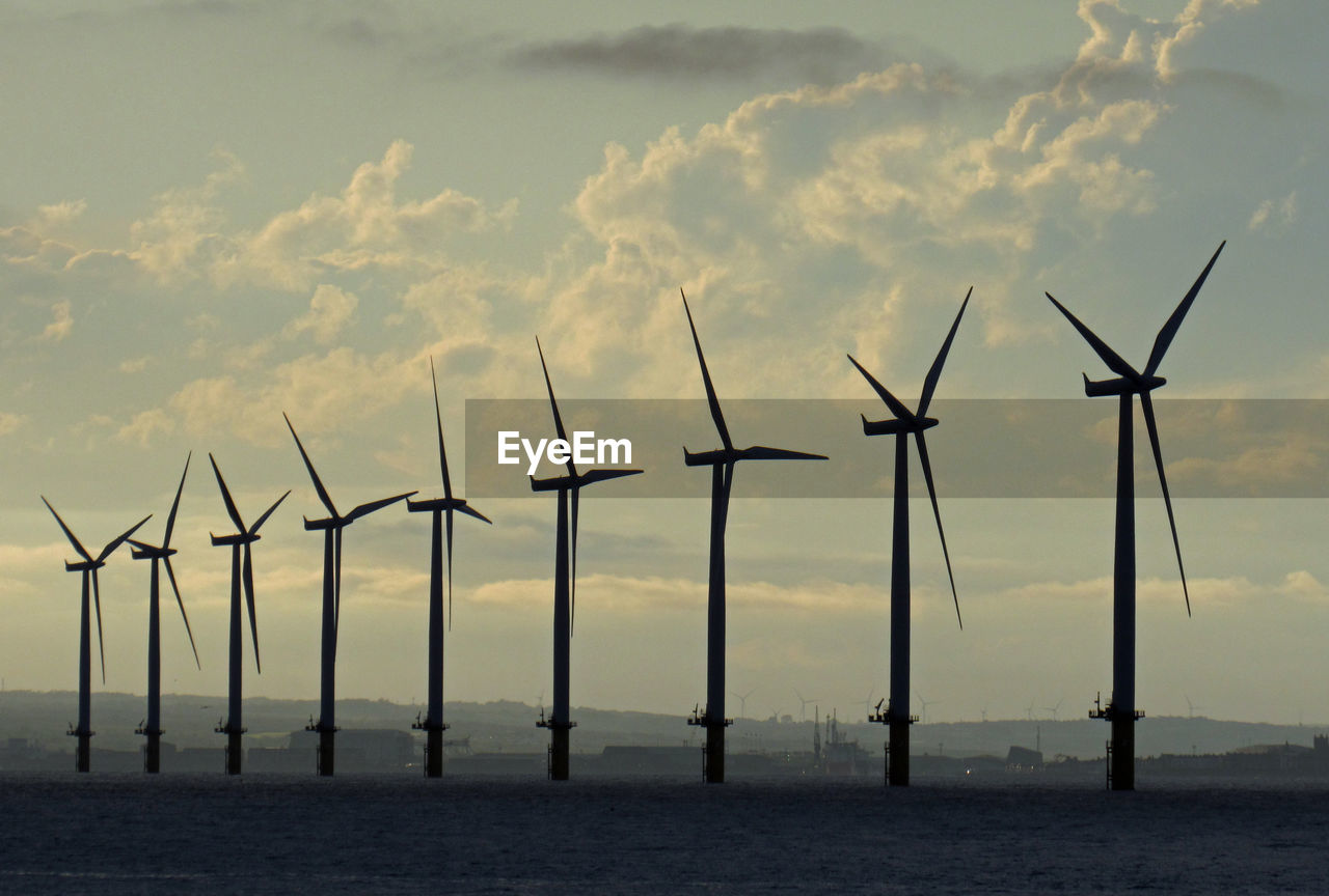 WIND TURBINES BY SEA AGAINST SKY