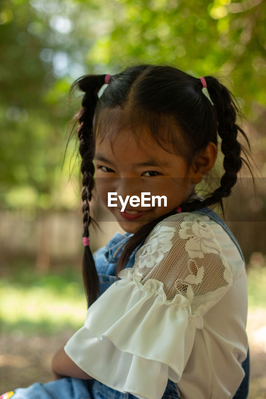 Portrait of cute happy girl on field