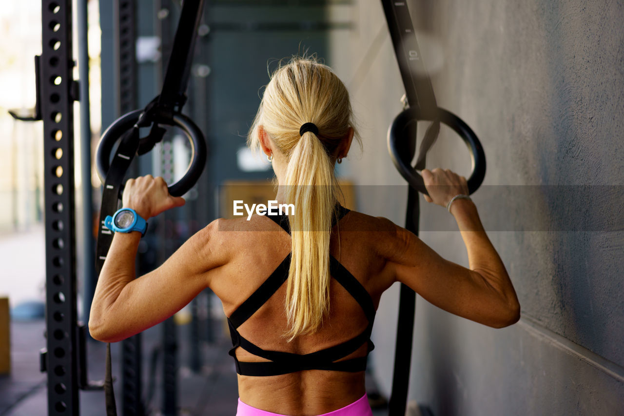 low section of woman holding rope in gym