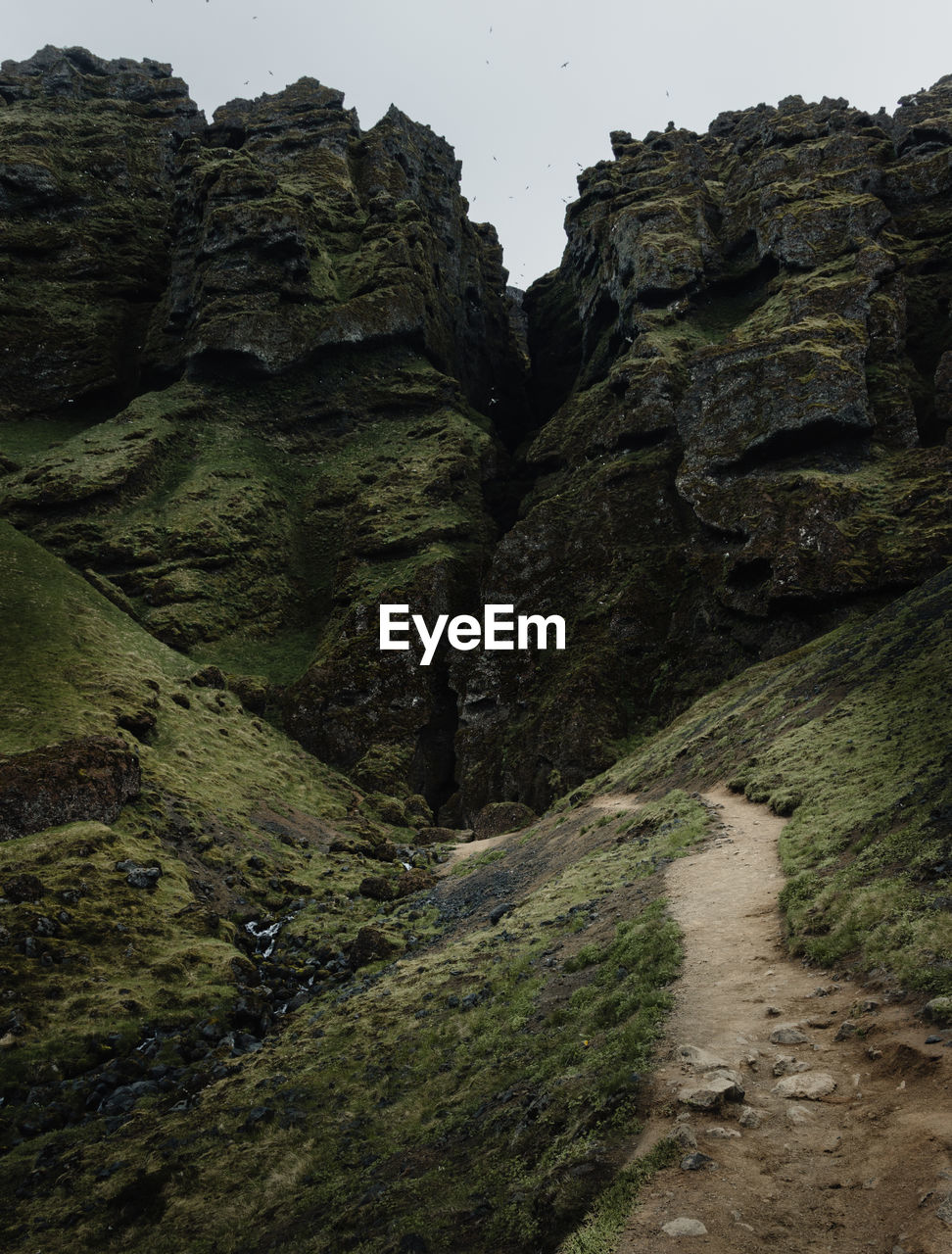 LOW ANGLE VIEW OF ROCKS IN MOUNTAINS AGAINST SKY