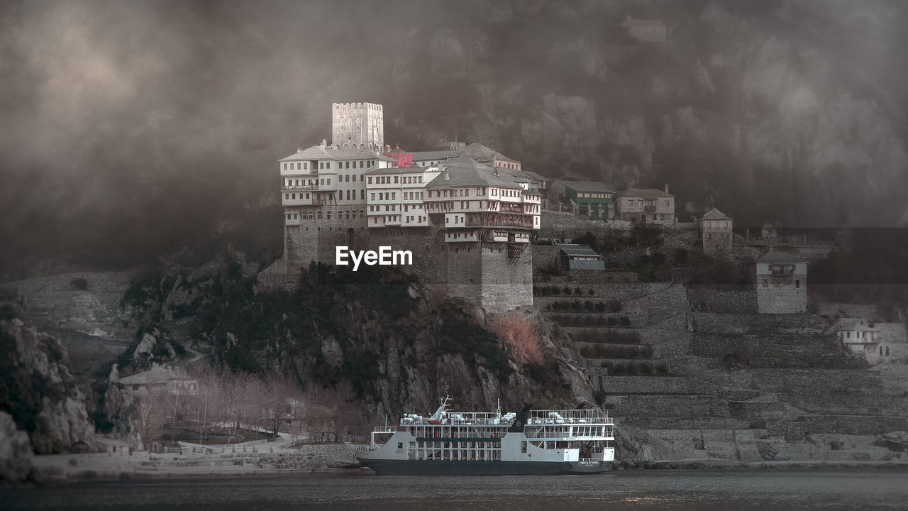 buildings by river against sky