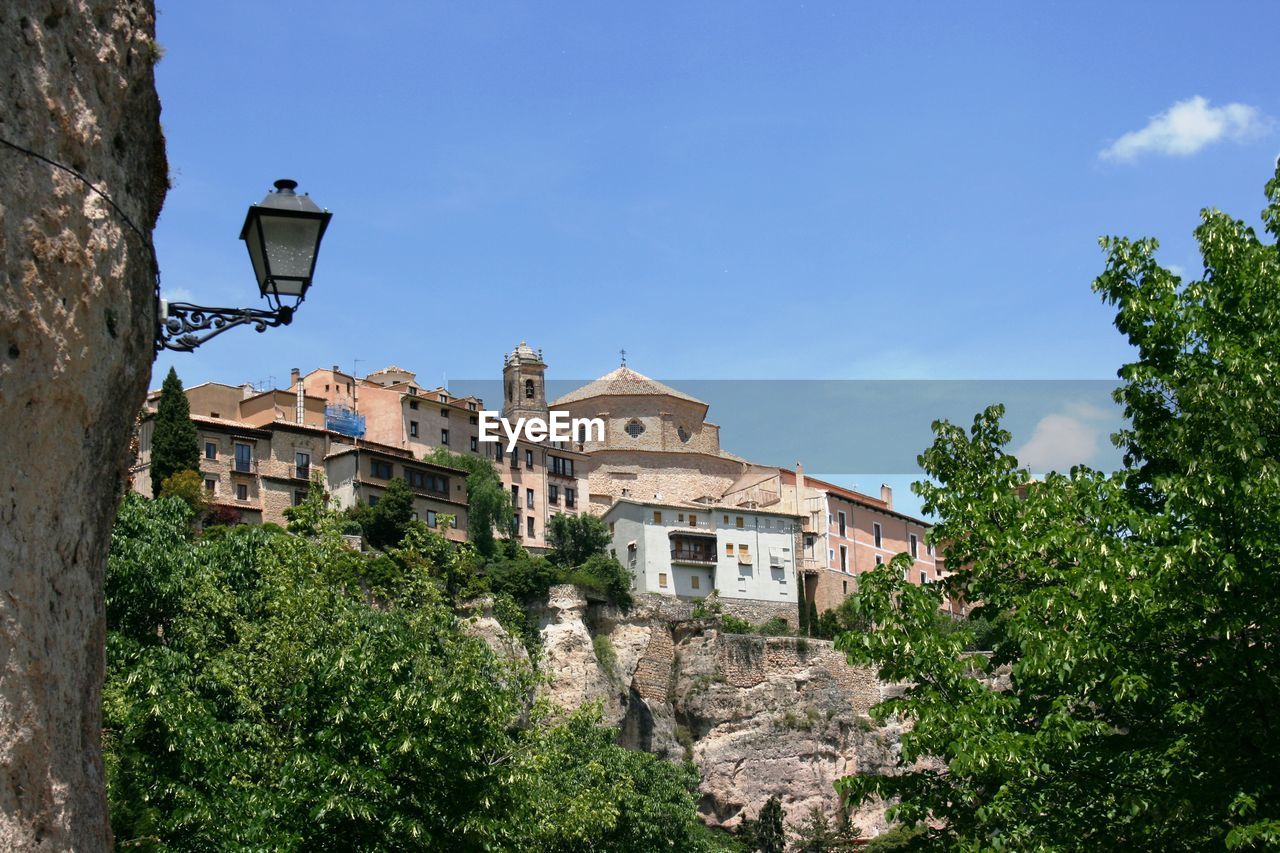 Low angle view of trees and buildings against sky