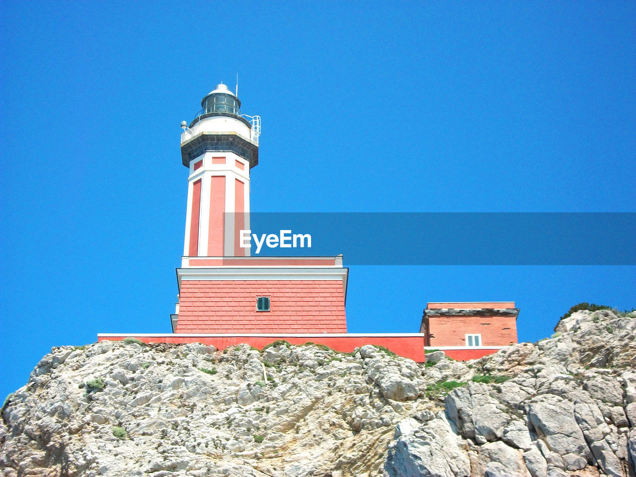 Low angle view of lighthouse against clear blue sky