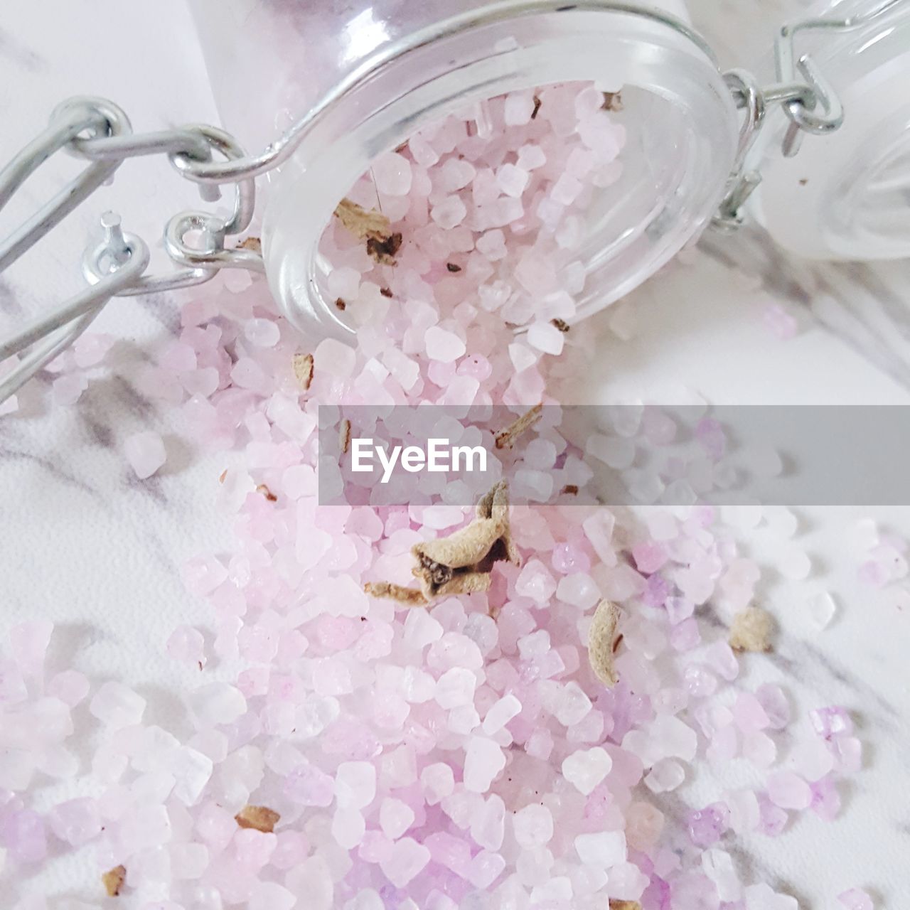 HIGH ANGLE VIEW OF PINK ROSES IN GLASS CONTAINER ON FLOOR