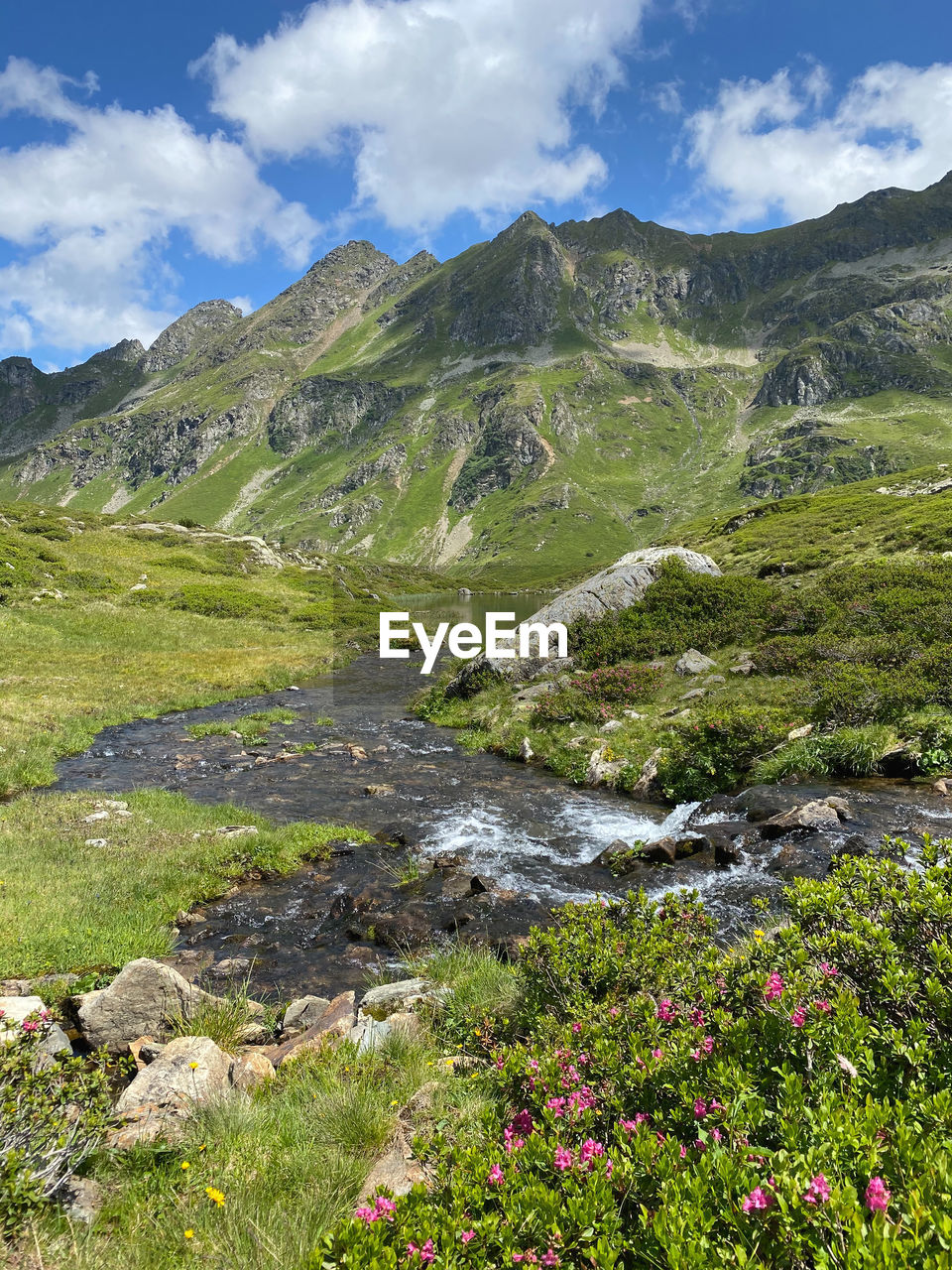 SCENIC VIEW OF STREAM FLOWING THROUGH MOUNTAINS