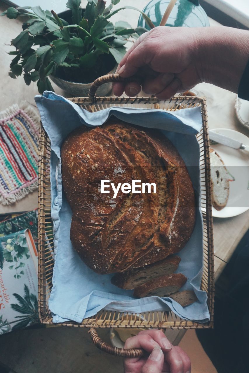 High angle view of person holding bread in plate