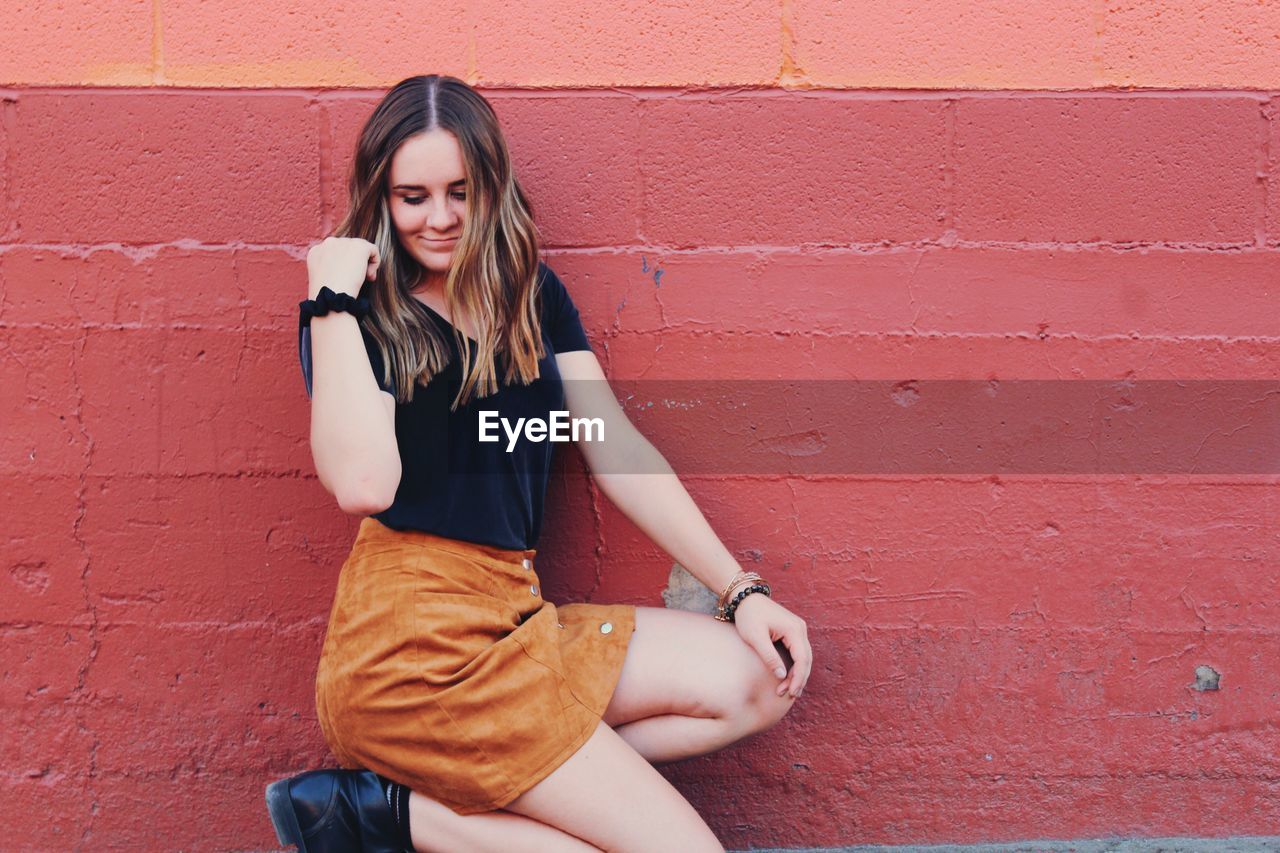 Beautiful young woman against wall