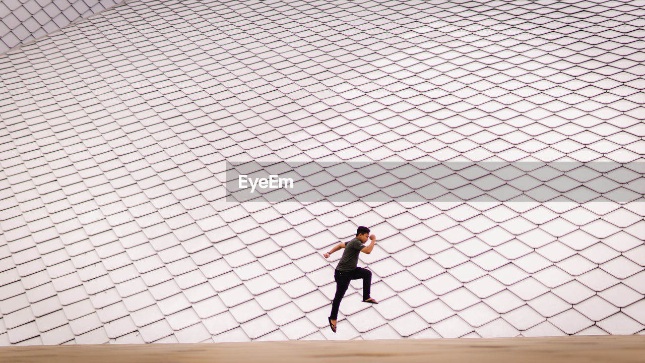 Man jumping with minimalist design as background. jumping higher. success concept. futuristic.