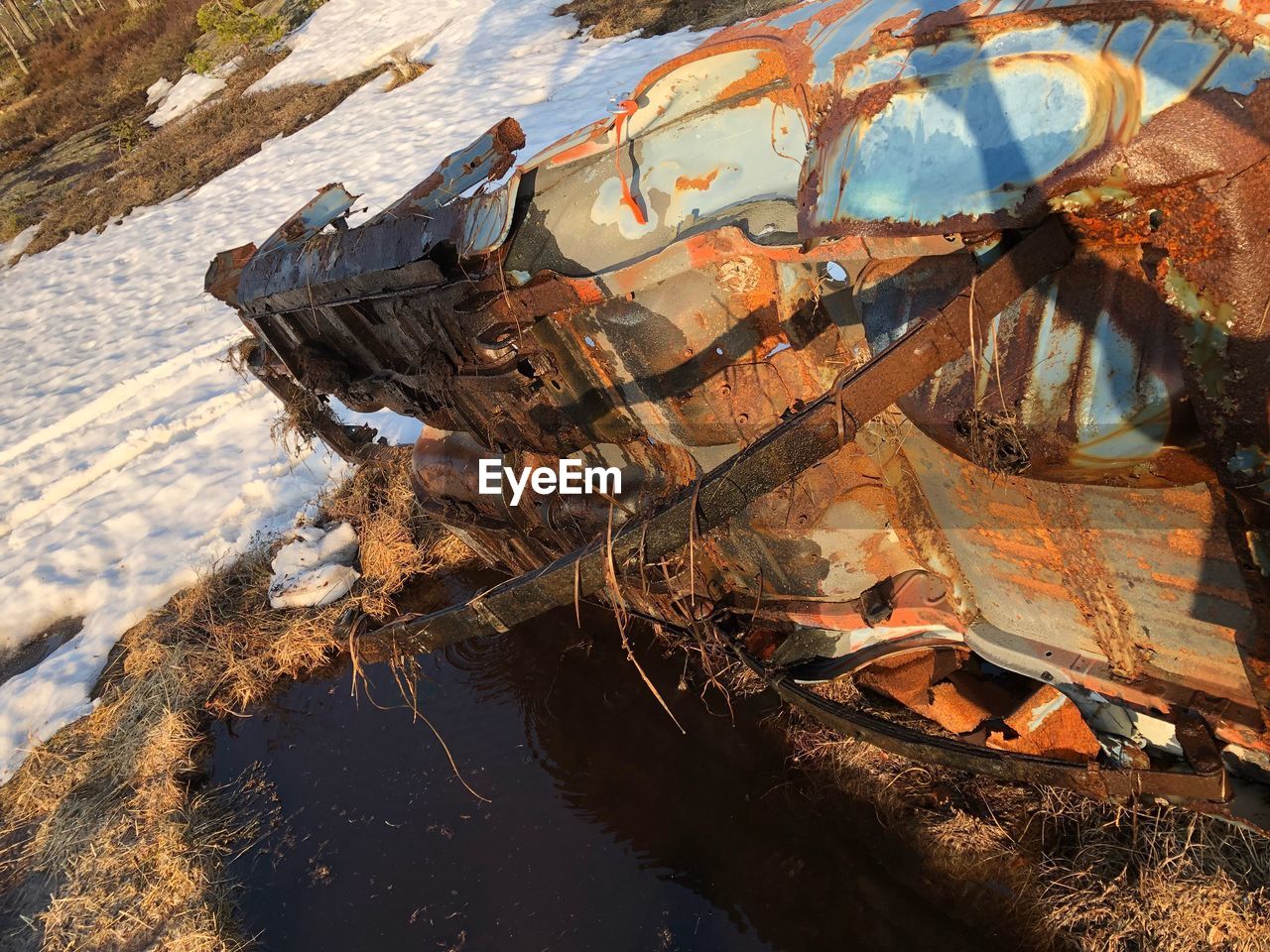 ABANDONED BOAT ON FIELD BY WATER