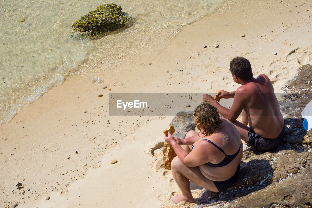 MEN SITTING ON BEACH