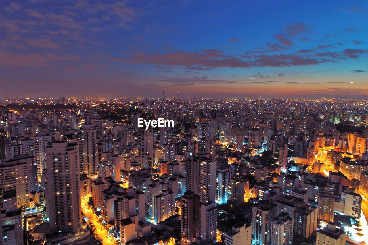 High angle view of illuminated city buildings against sky