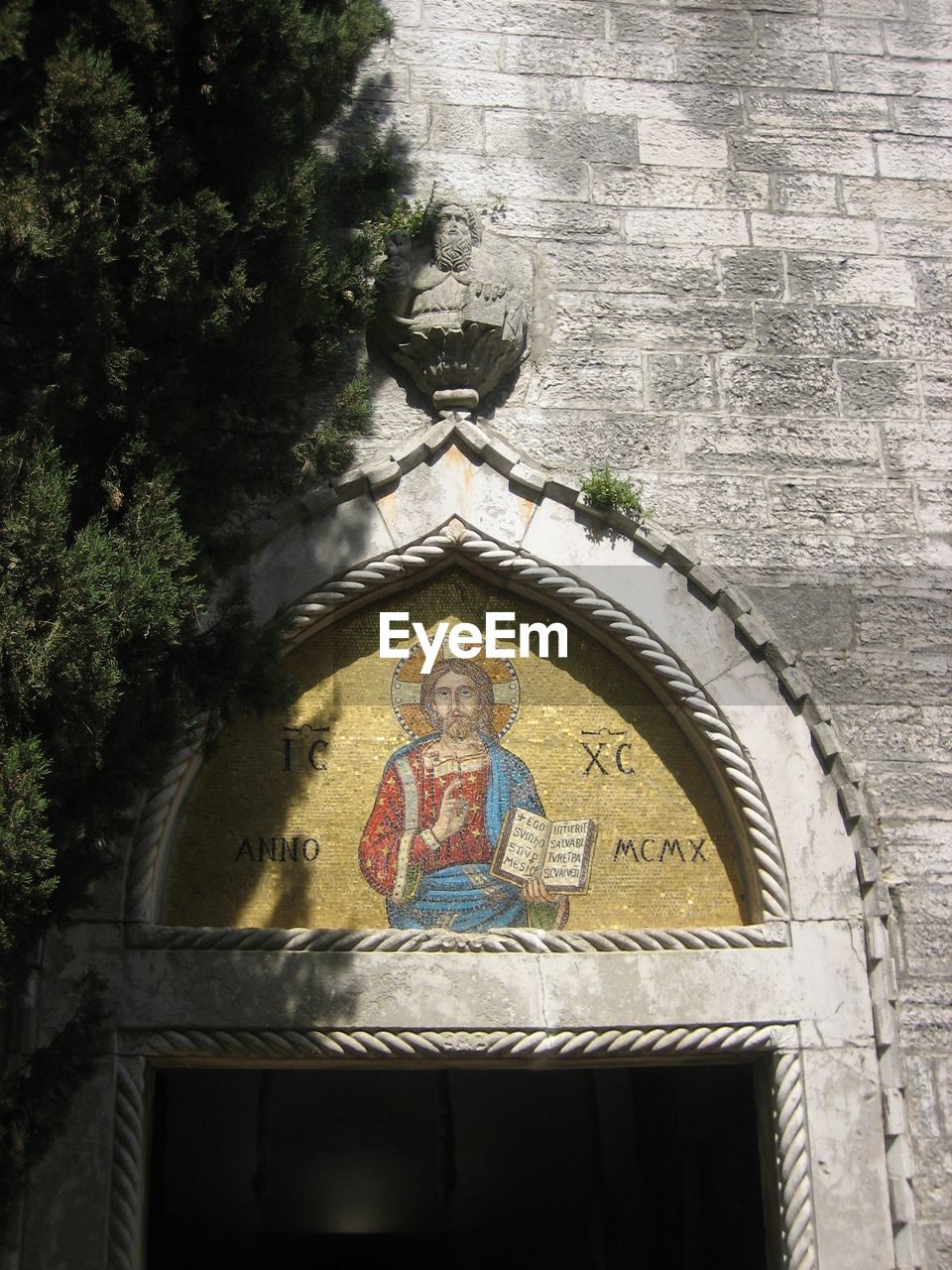 LOW ANGLE VIEW OF ANGEL STATUE AGAINST BUILDING AND WALL