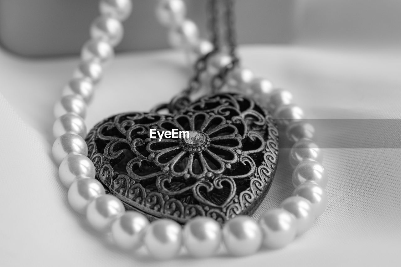 jewelry, jewellery, necklace, wealth, luxury, close-up, fashion accessory, pearl jewelry, silver, metal, indoors, no people, fashion, elegance, pendant, black and white, diamond, studio shot, chain, heart shape, pearl, bracelet, gemstone, selective focus, locket, love, focus on foreground, pattern